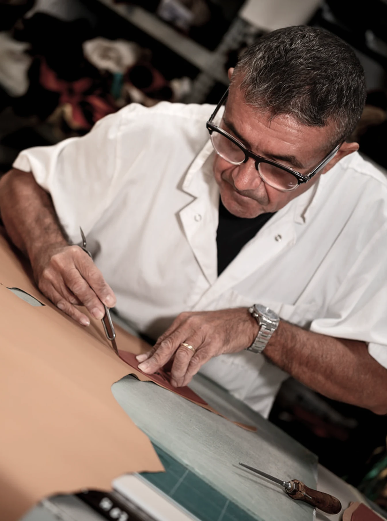 Artigiano durante il taglio manuale della pelle per calzature